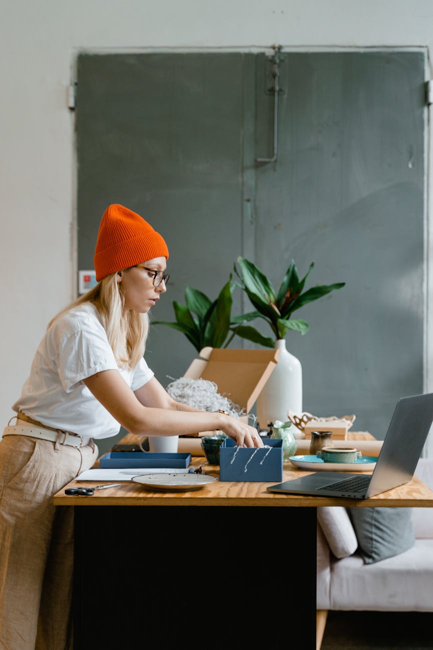 a woman in red beanie putting the cut out papers in the box