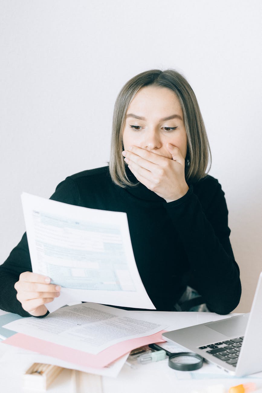 woman in black long sleeve shirt covering her face with her hand