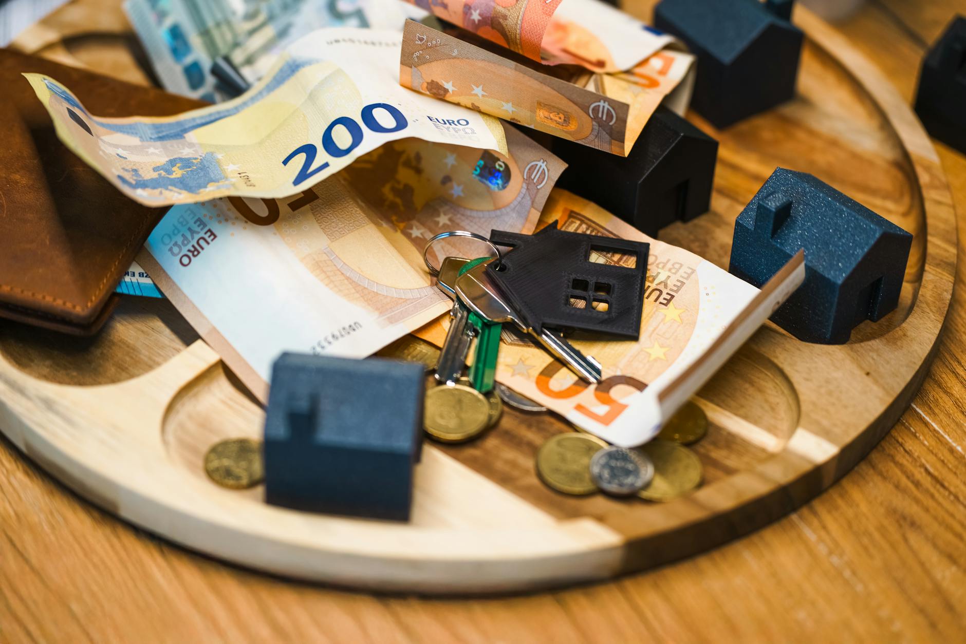 euro banknotes and keys with miniature houses