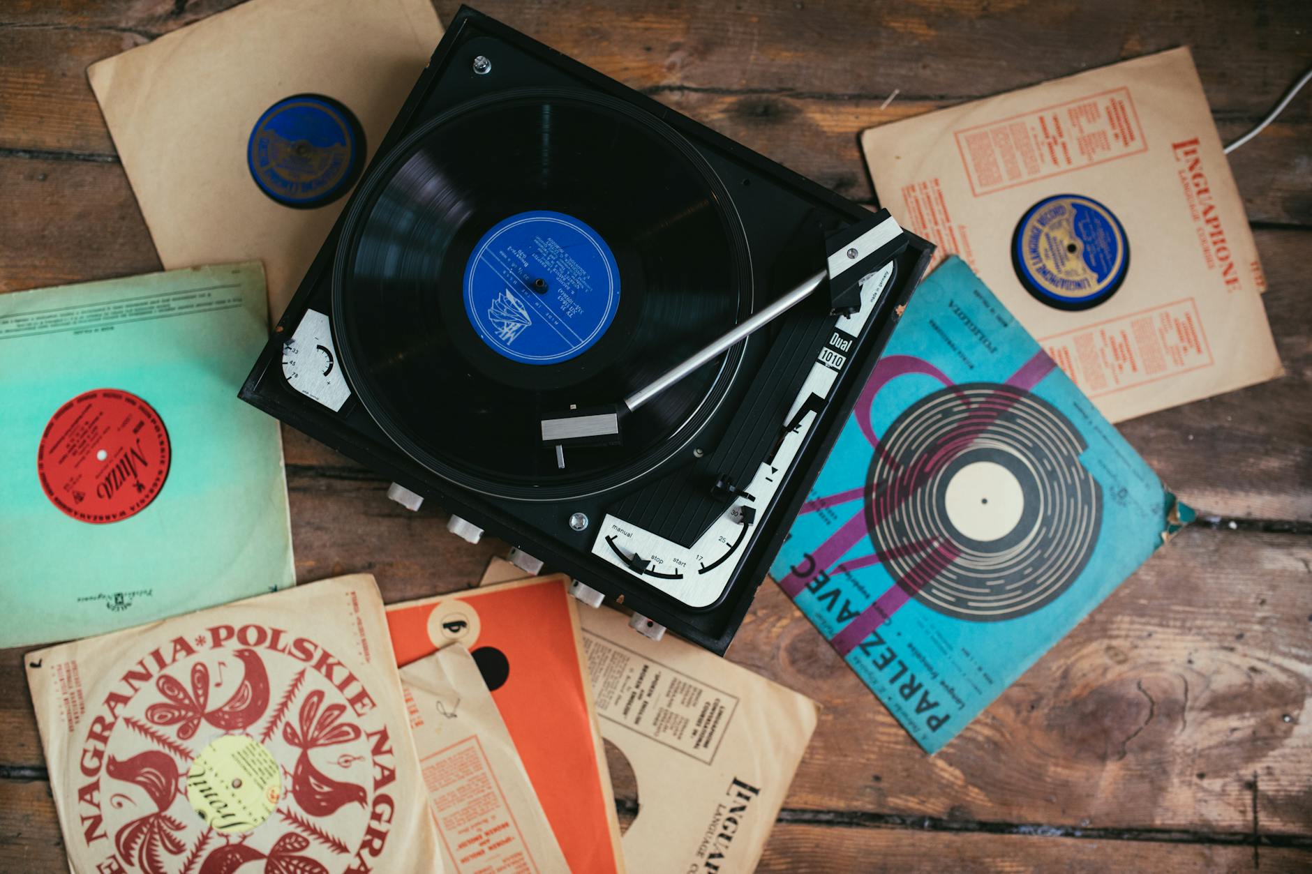 vinyl records and turntable on wooden floor