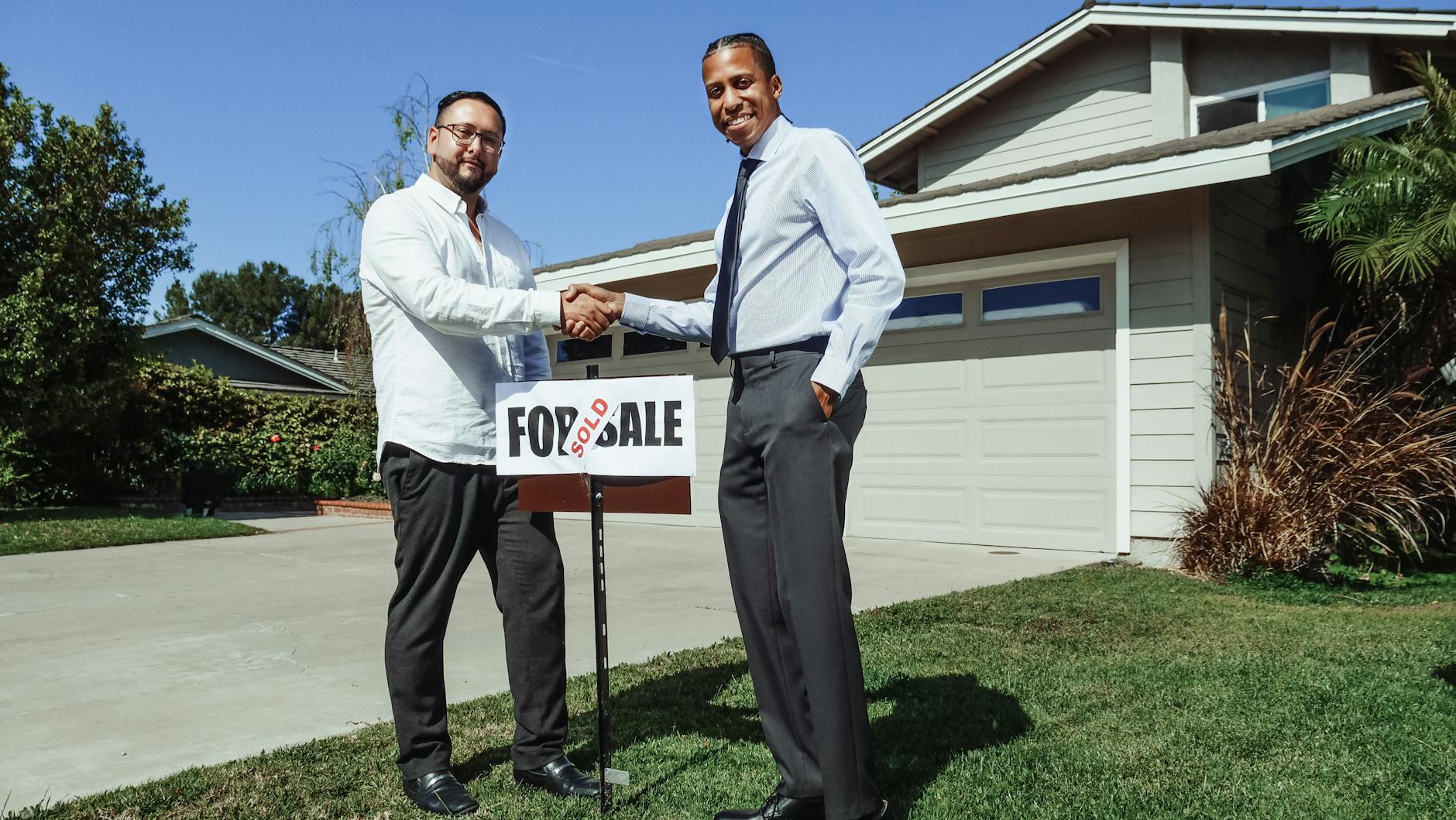 men in dress shirt in front of a house