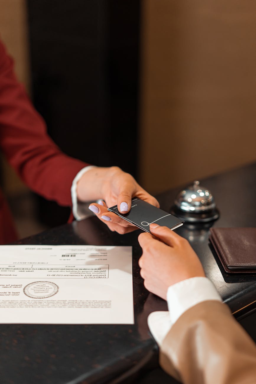 a hotel receptionist handing a key card to a guest