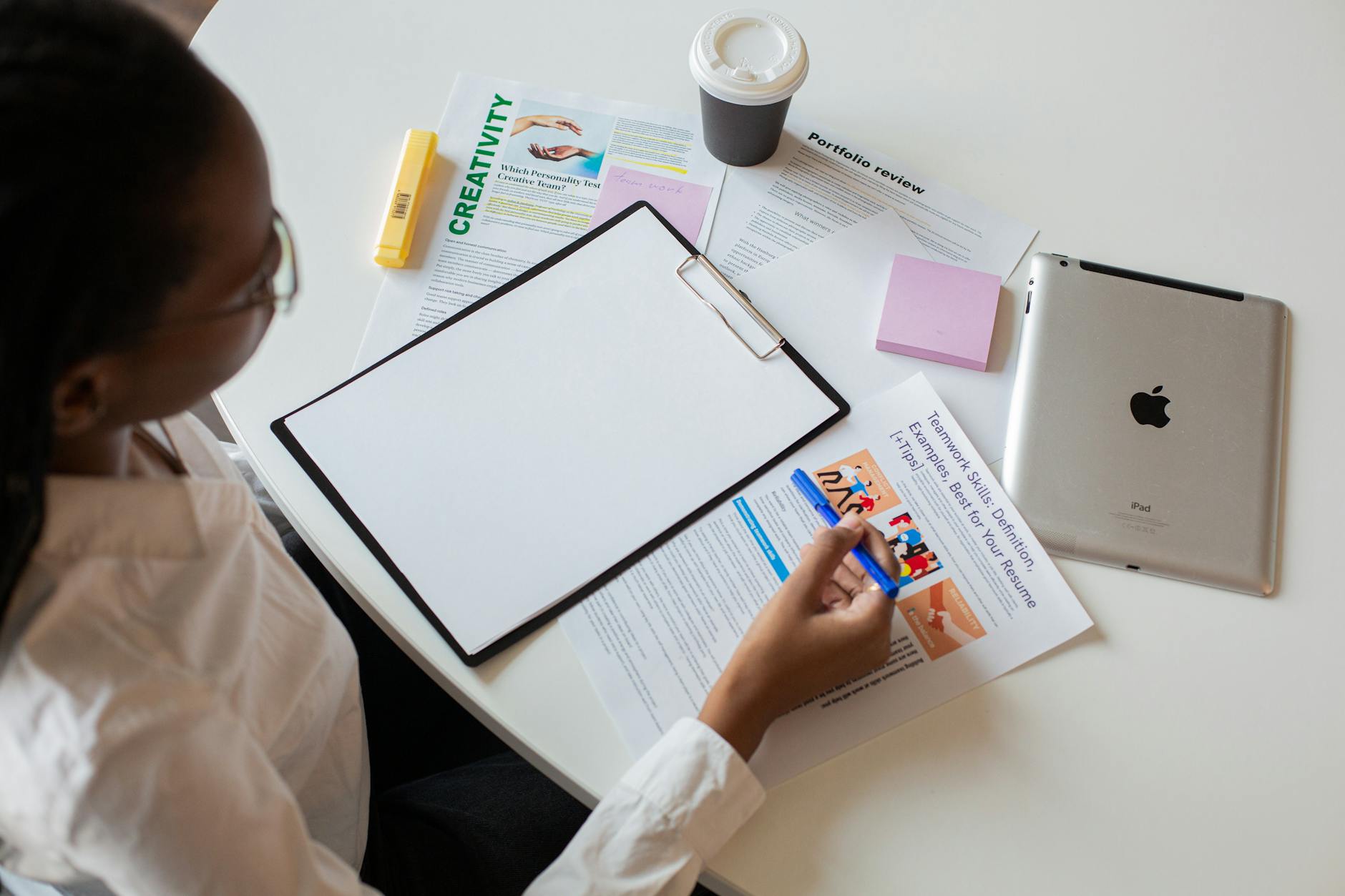 a woman holding a pen while looking at documents