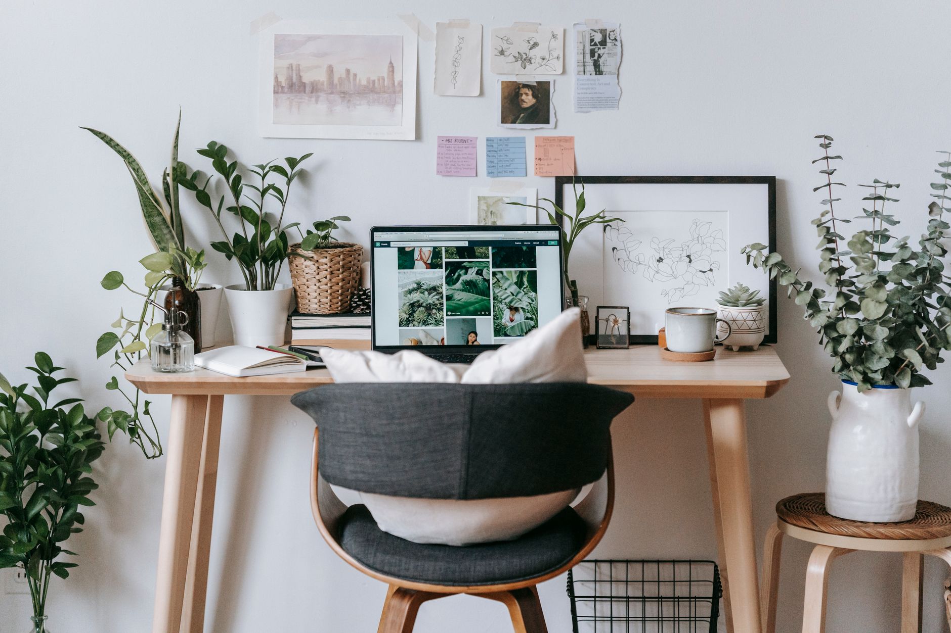 comfortable workplace with laptop and green plants at table